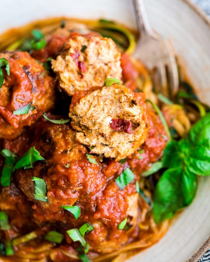 up close view of a Healthy Turkey Meatball cut in half on top of other meatballs in sauce