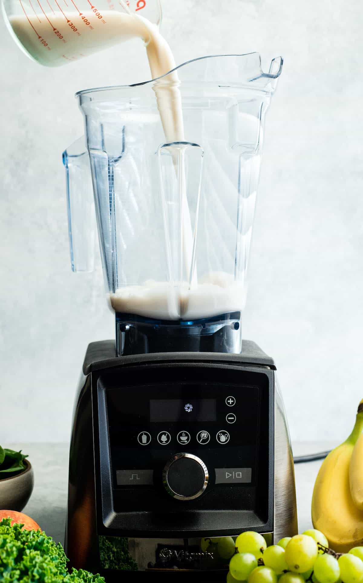 front view of almond milk being poured into the Vitamix A3500 blender to make this Green Smoothie Recipe