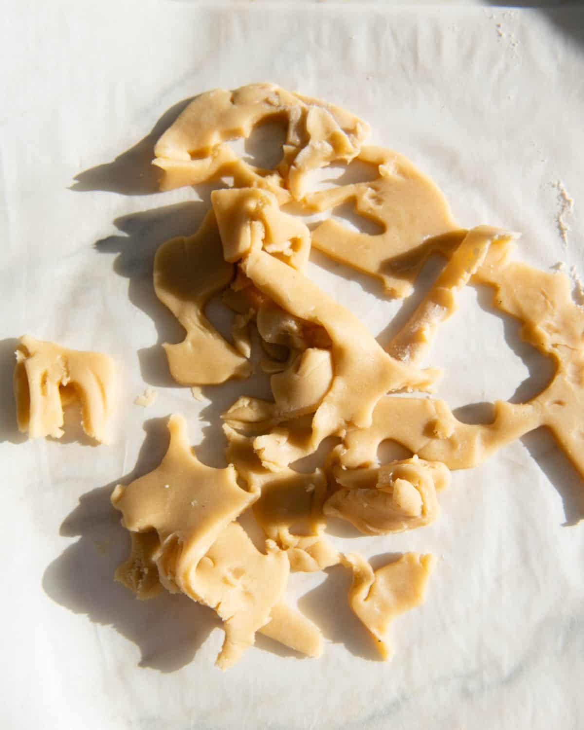 making sugar cookies recipe cut outs - dough scraps on parchment paper
