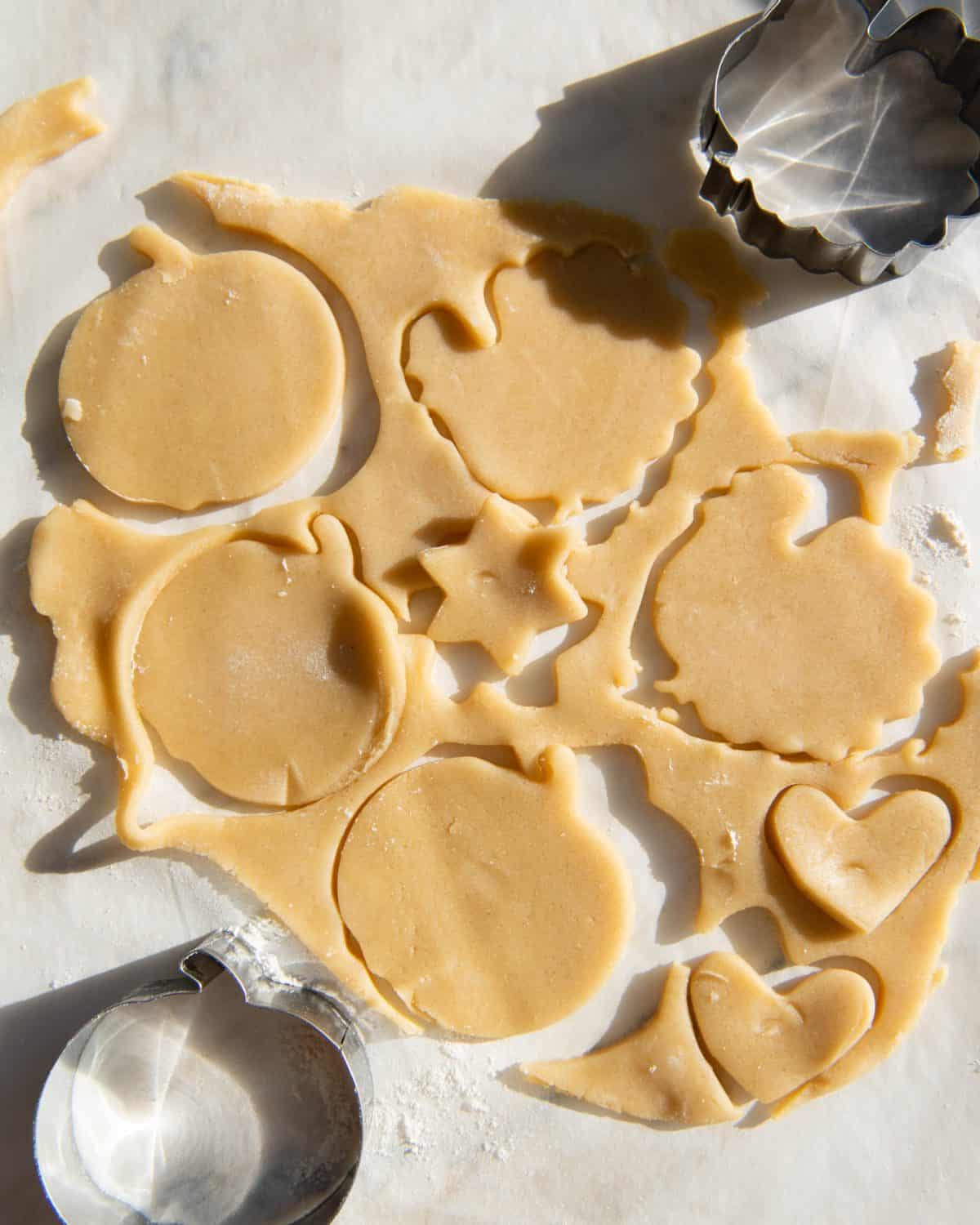 making sugar cookies recipe cut outs - re-rolled out dough cut into shapes pumpkins, turkeys, a star, and hearts.