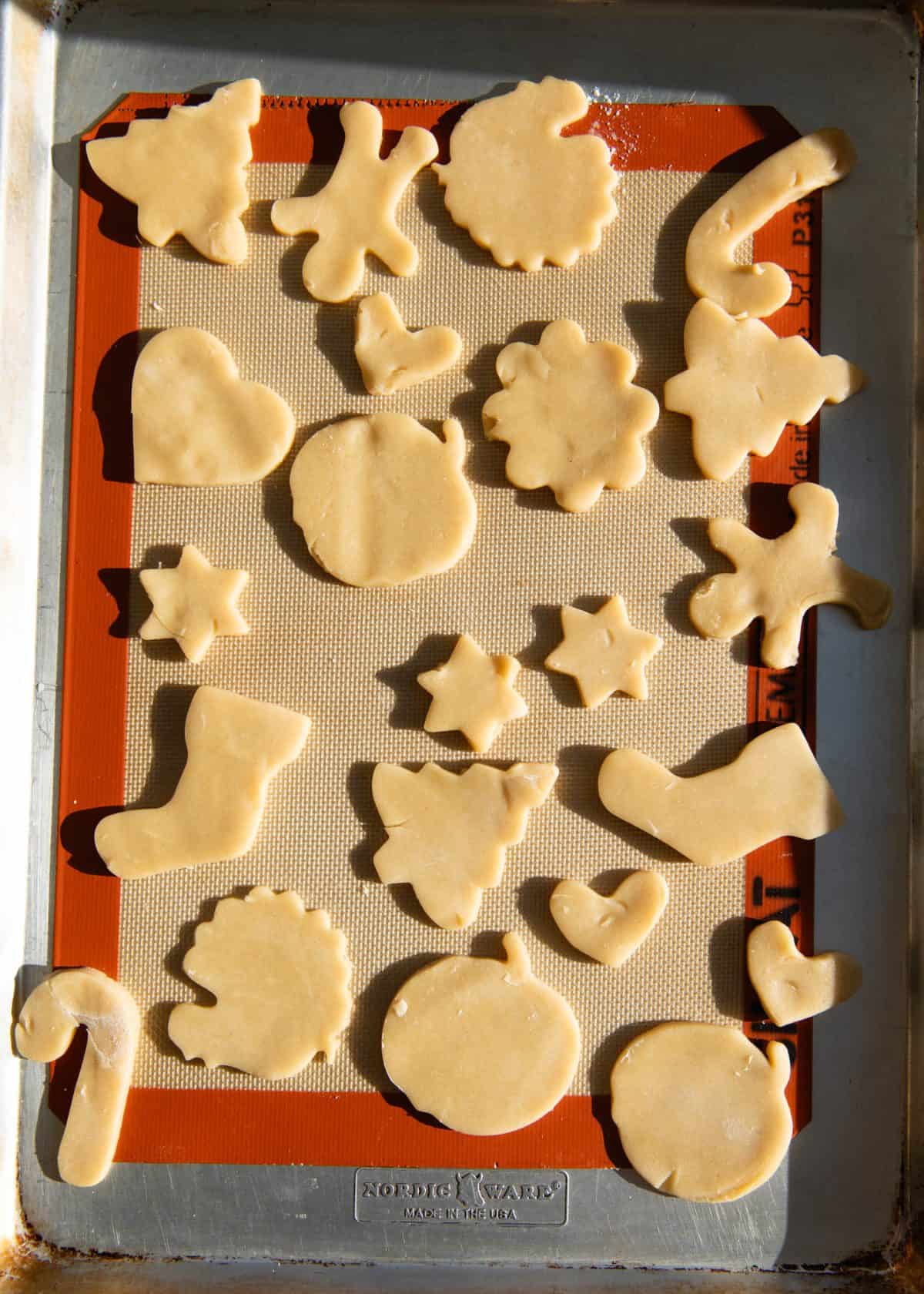 cut out sugar cookies on a baking sheet lined with a silicone baking mat before baking. Cut into shapes like hearts, turkeys, Christmas trees, gingerbread men, stockings, pumpkins, stars and more.