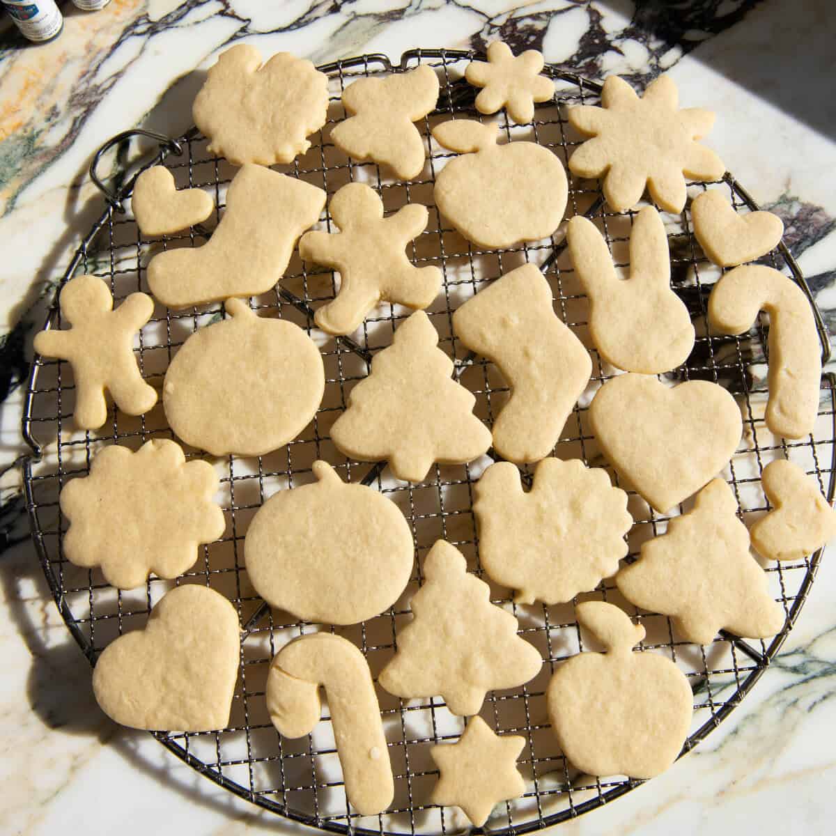 cut out sugar cookies on a wire cooling rack after baking. Cut into shapes like hearts, turkeys, Christmas trees, gingerbread men, stockings, pumpkins, stars, bunnies, and more.