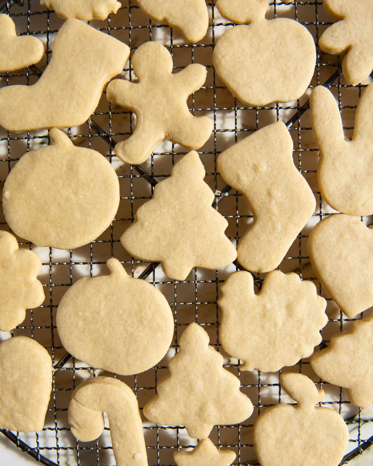 cut out sugar cookies on a wire cooling rack after baking. Cut into shapes like hearts, turkeys, Christmas trees, gingerbread men, stockings, pumpkins, stars, bunnies, and more.