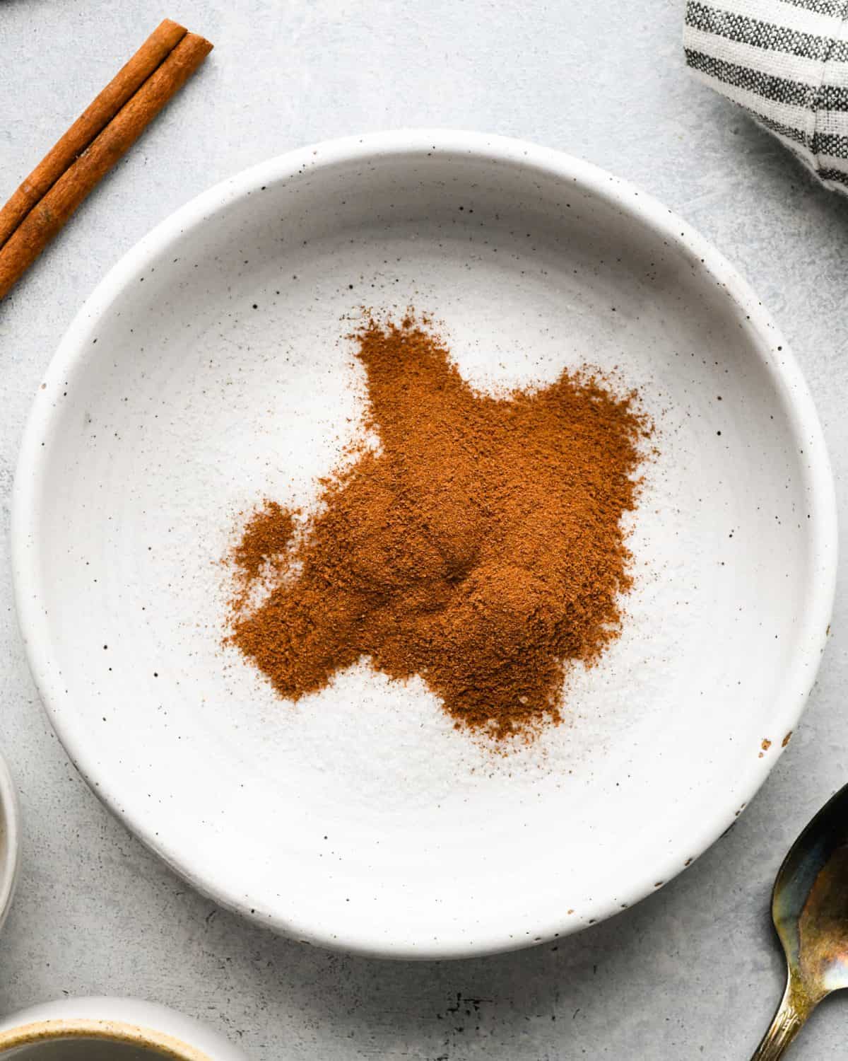 making snickerdoodles - sugar and cinnamon in a small white ceramic bowl before mixing