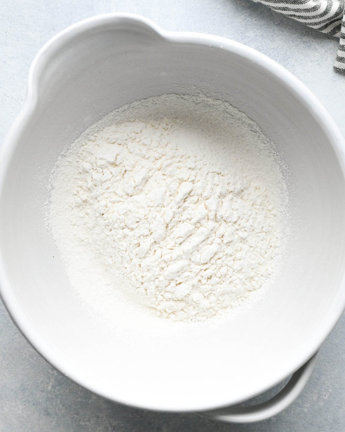 making snickerdoodles - sifted flour in a white ceramic mixing bowl