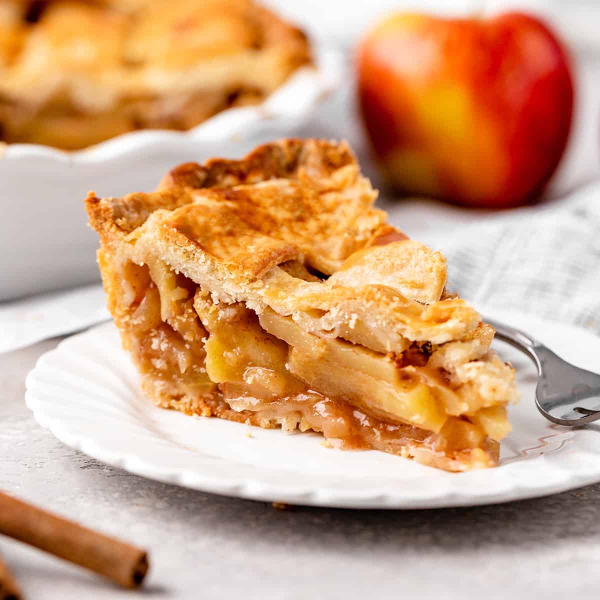 a slice of apple pie on a plate with a fork