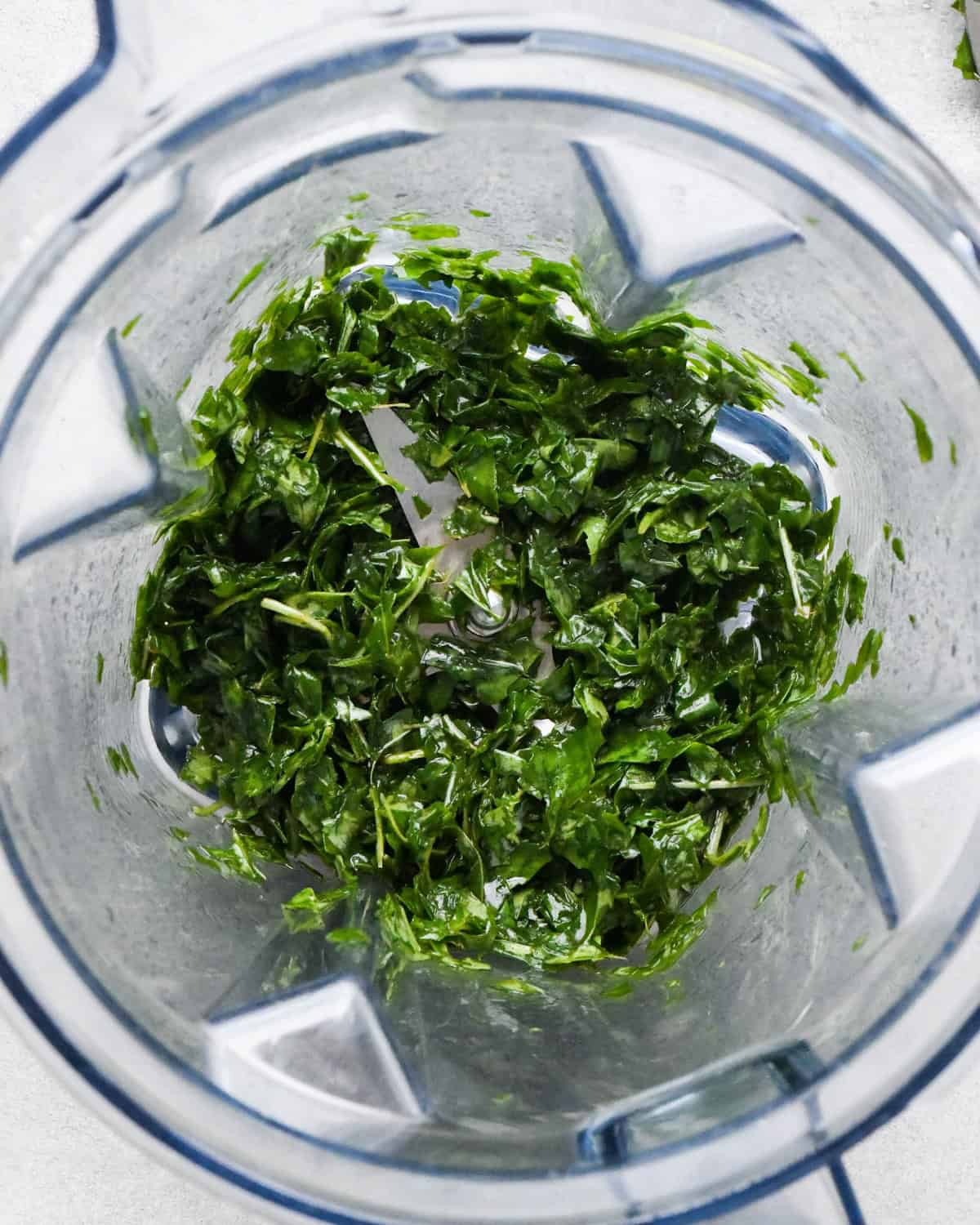 making pesto pasta sauce in a blender, basil and olive oil in the container after blending