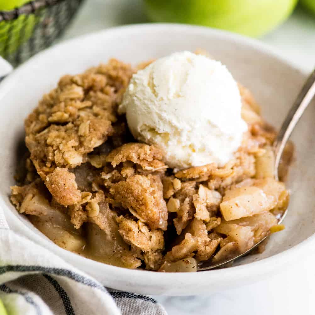 up close view of a bowl of apple crisp with ice cream on top