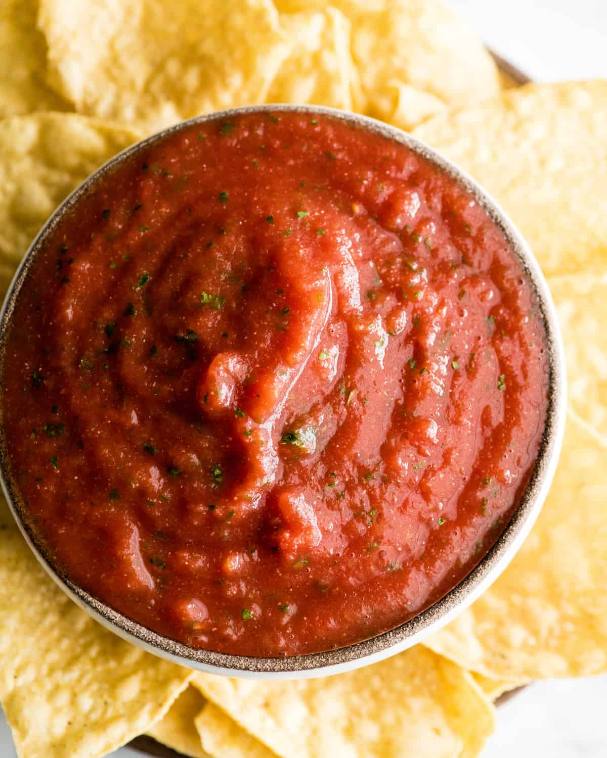 overhead view of a bowl of homemade salsa and chips
