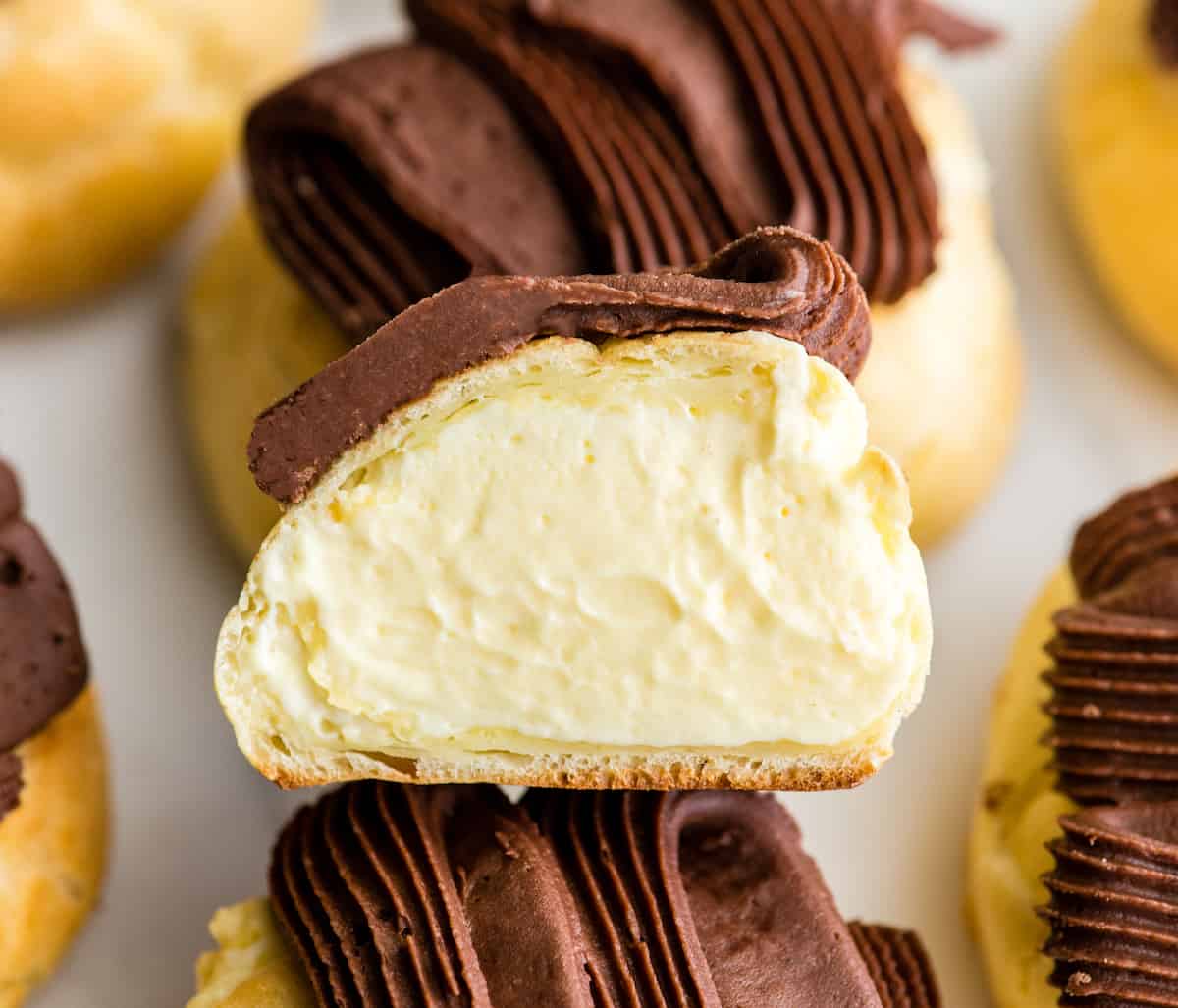 overhead view of a half of a homemade eclair laying down so you can see the filling inside.