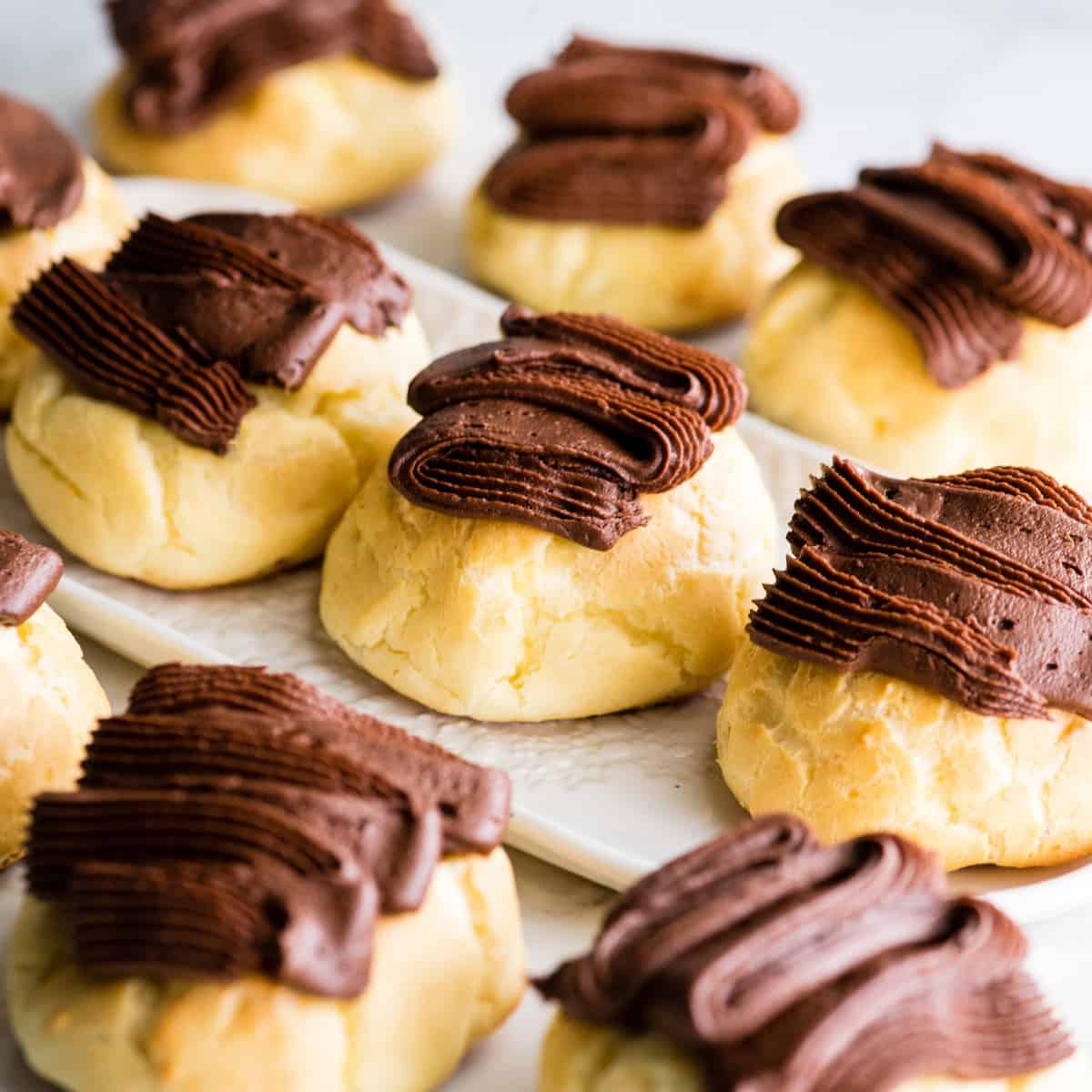 front view of 8 Homemade Eclairs, some on a serving plate