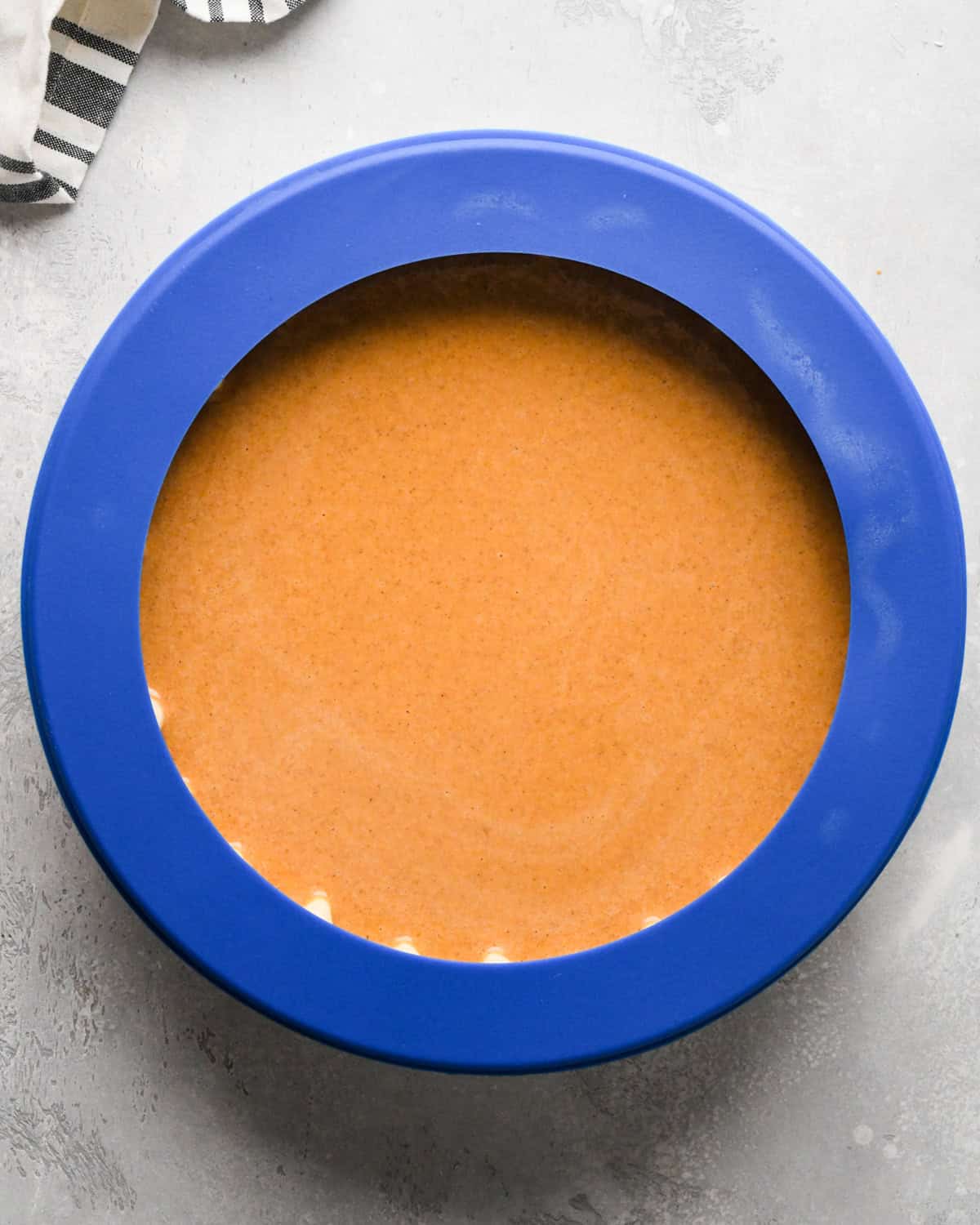 pumpkin pie before baking with a blue pie crush shield around the outer edge to protect the crust