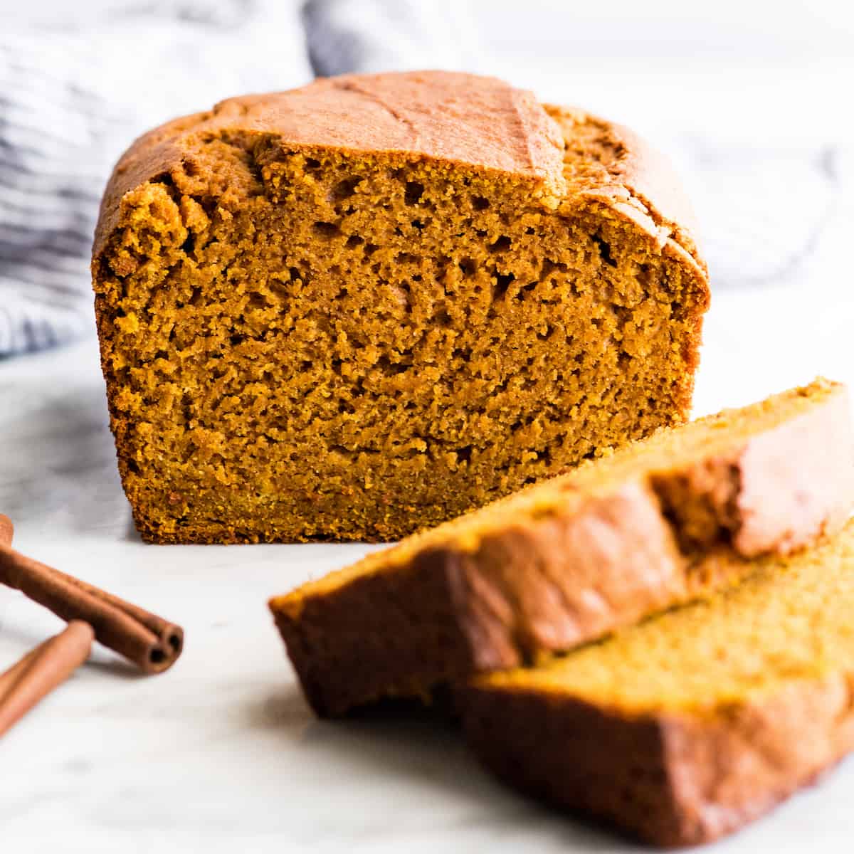 front view of a loaf of pumpkin bread with two slices cut out of it