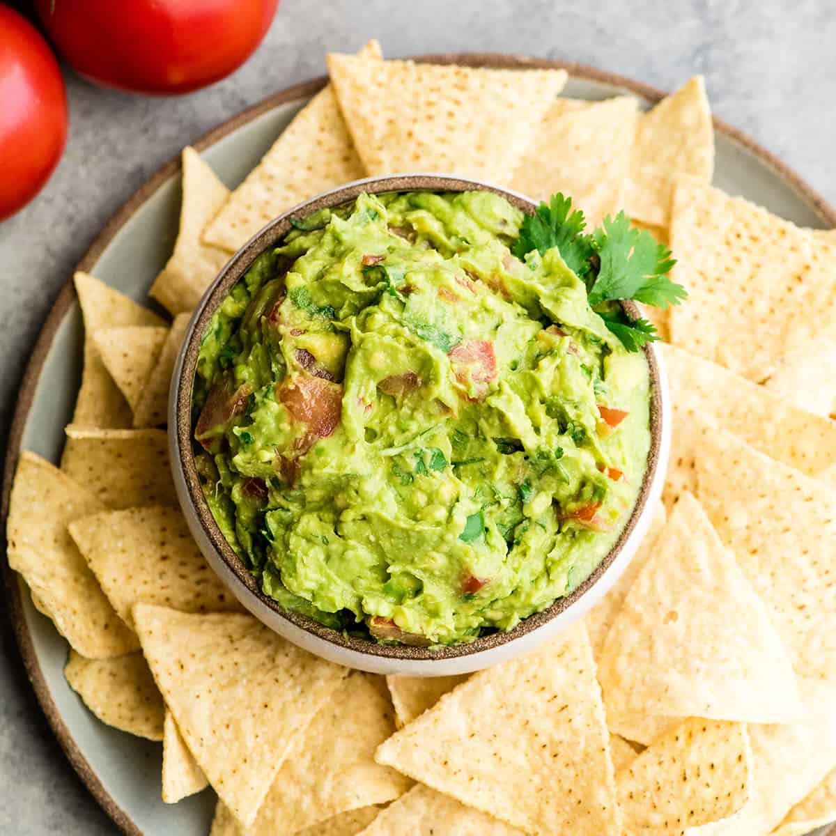 overhead view of a bowl of guacamole surrounded by chips