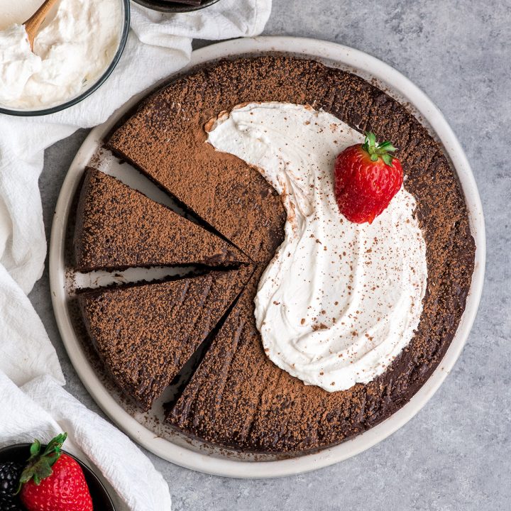 Overhead view of a Flourless Chocolate Cake on a plate with two pieces cut