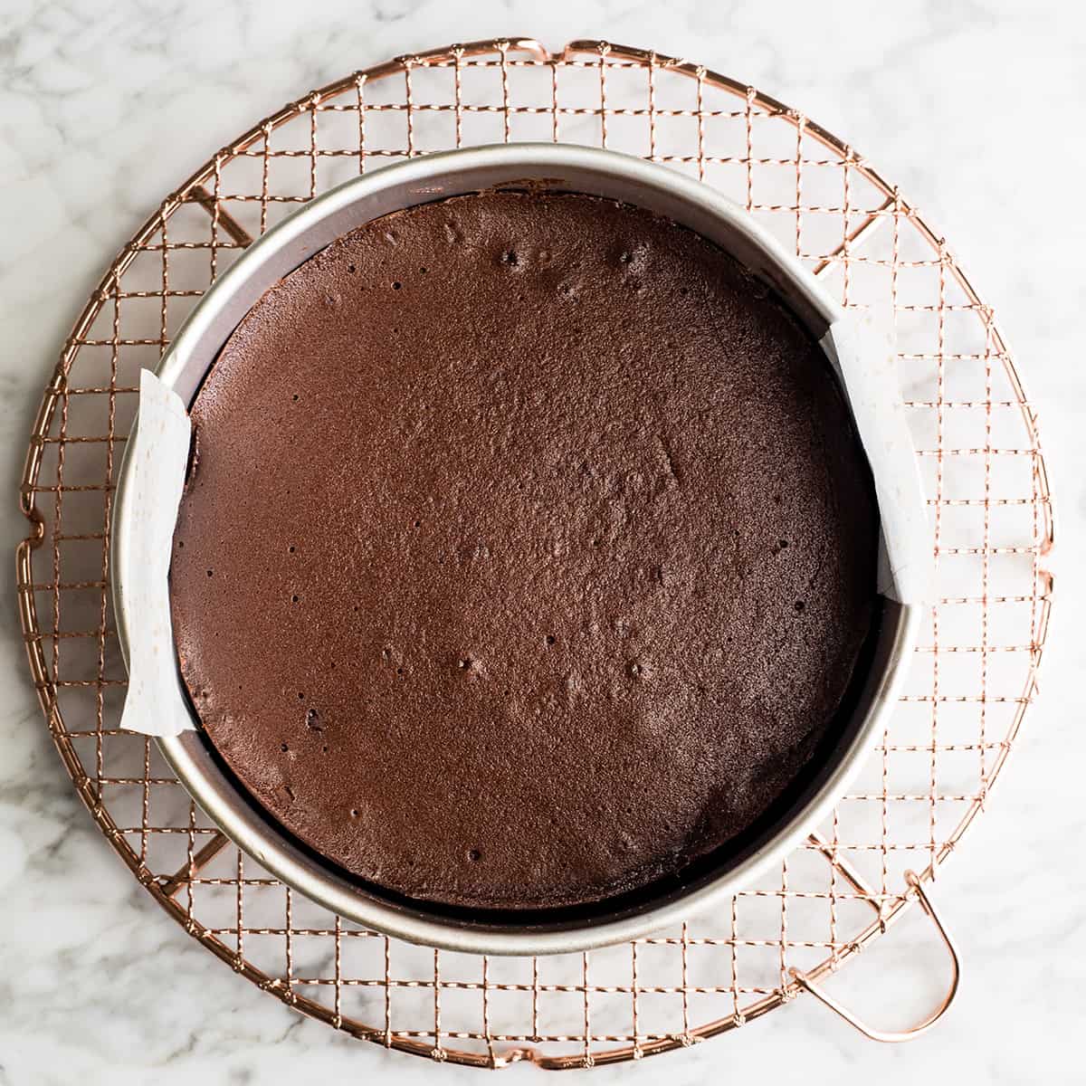overhead view of flourless chocolate cake on a cooling rack