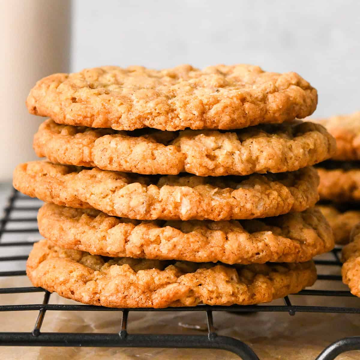 a stack of five oatmeal cookies on a wire cooling rack
