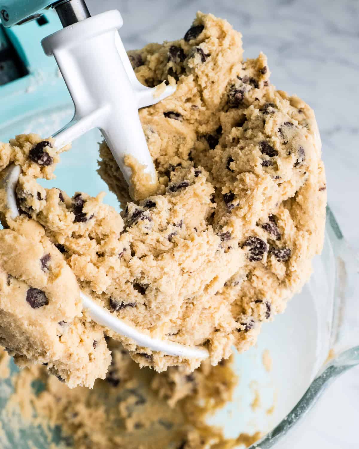 overhead view of chocolate chip cookie bar dough in a standing mixer