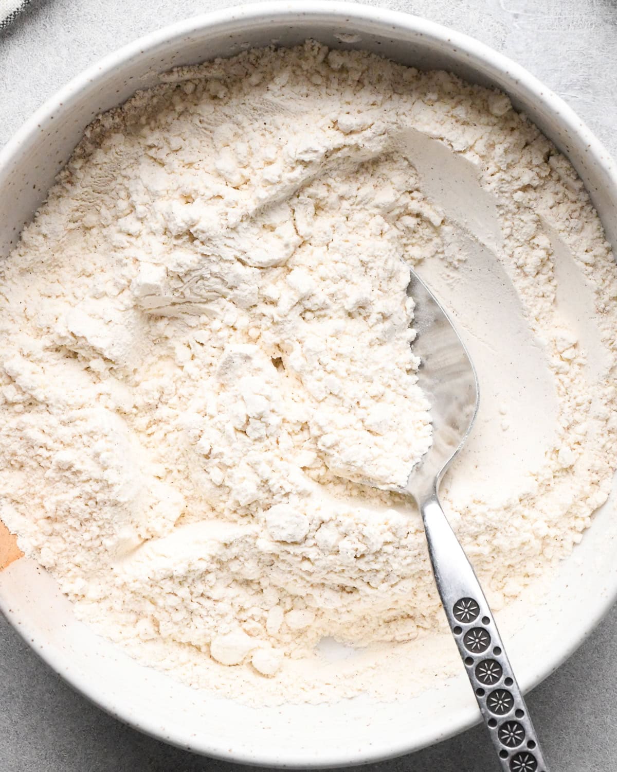 a bowl of the dry ingredients in this oatmeal cookie recipe with a spoon