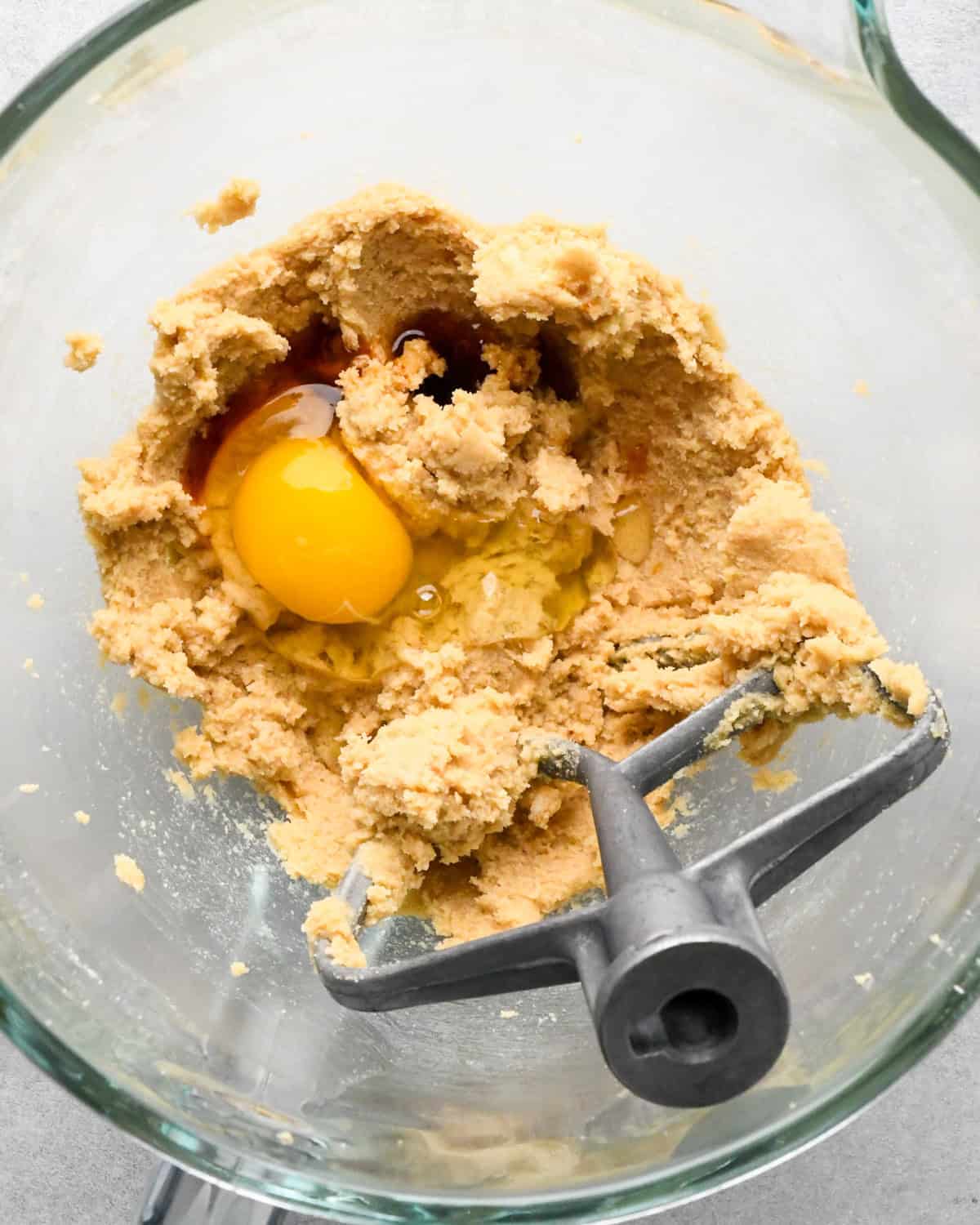 egg and vanilla added to butter and sugar mixture in a mixing bowl with the paddle attachement before beating