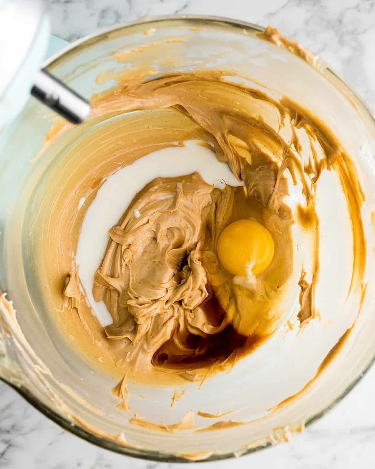 making Peanut Butter Blossoms recipe in a standing mixer - addin gegg, vanilla and milk