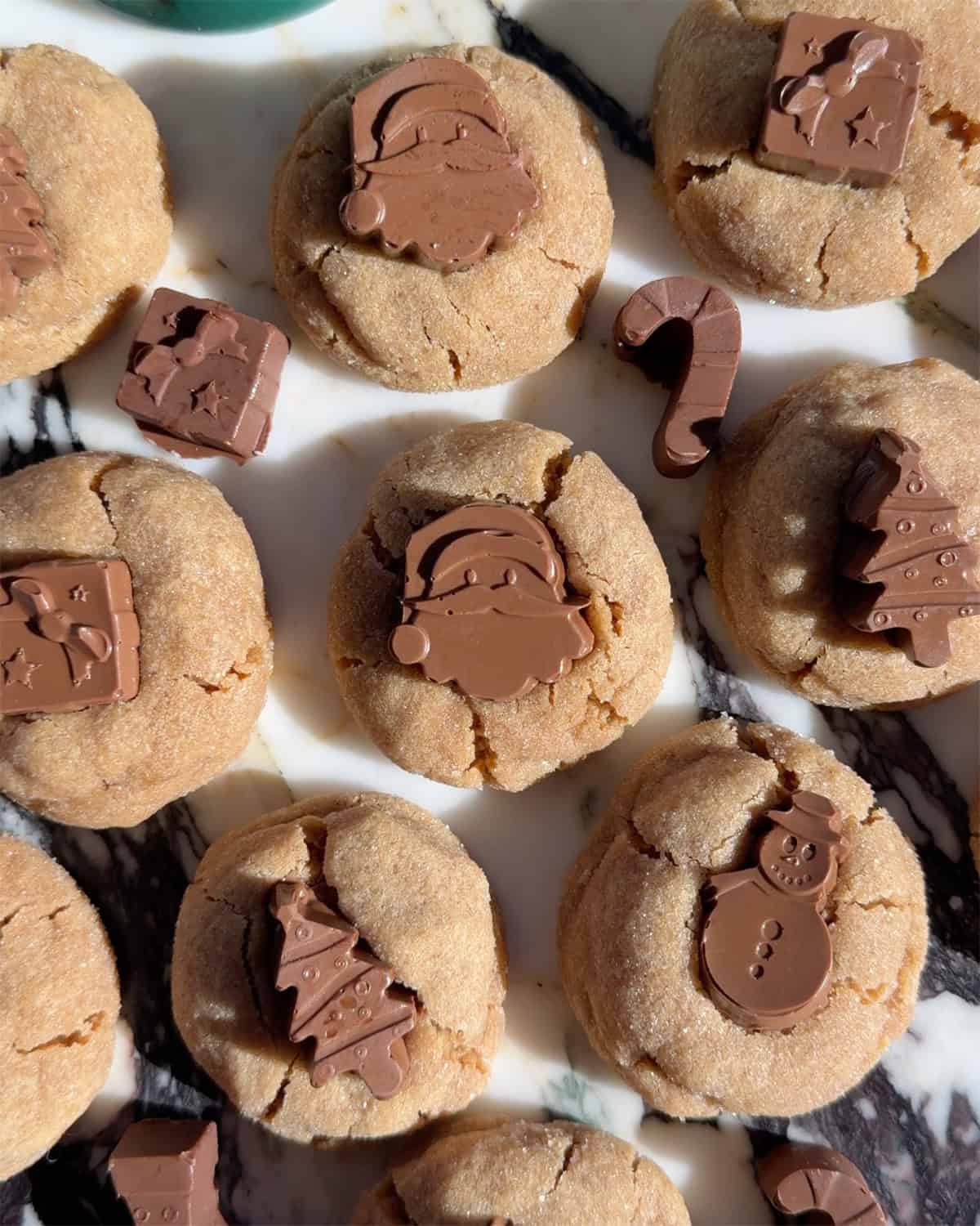 peanut butter blossoms with festive holiday chocolate shapes in them like santas, presents, Christmas trees and candy canes.