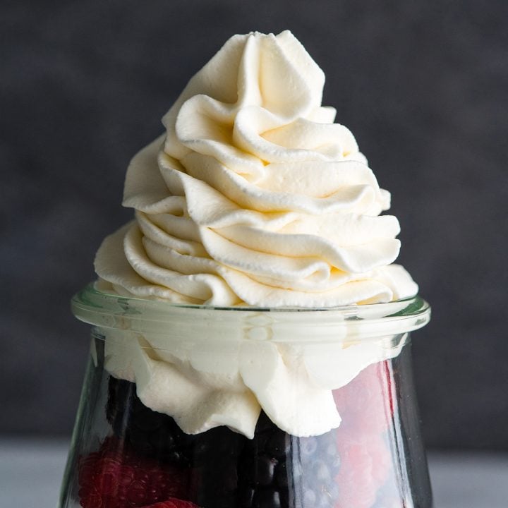 Font view of homemade whipped cream piped on top of fresh berries