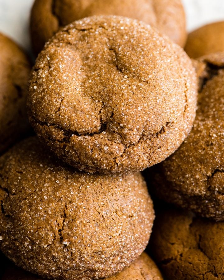 These Soft Gingerbread Cookies are the BEST gingerbread cookies ever! They have crispy edges with soft and chewy centers and are perfectly spiced! Plus they are so easy to make - no rolling or cutting-out necessary to enjoy this rich & nostalgic gingerbread recipe! Roll them in sugar, add a simple gingerbread glaze or serve them plain! #gingerbreadcookies #christmascookies #gingerbread overhead view of soft gingerbread cookies rolled in sugar
