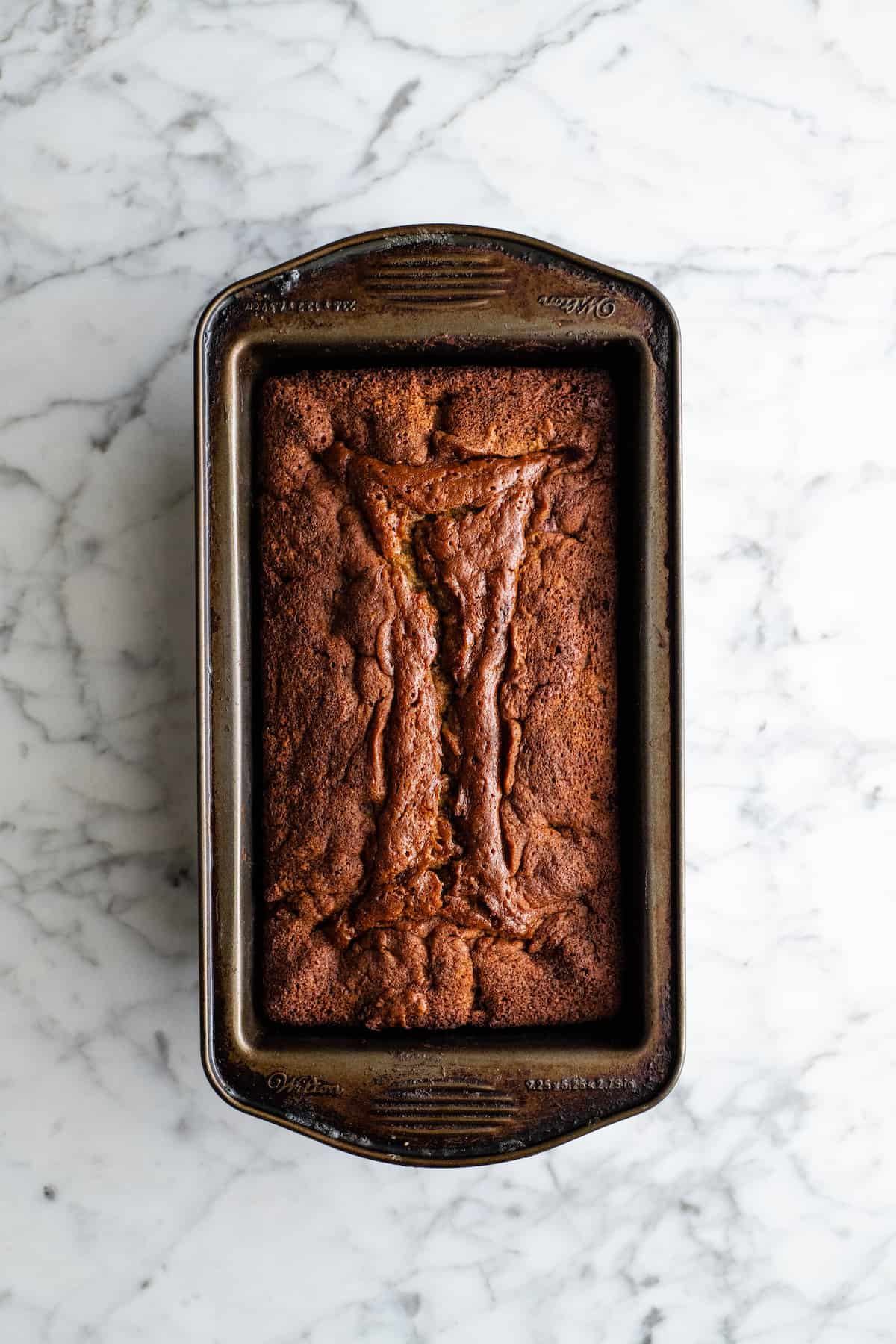 overhead view of a baked loaf of chocolate chip banana bread in a loaf pan