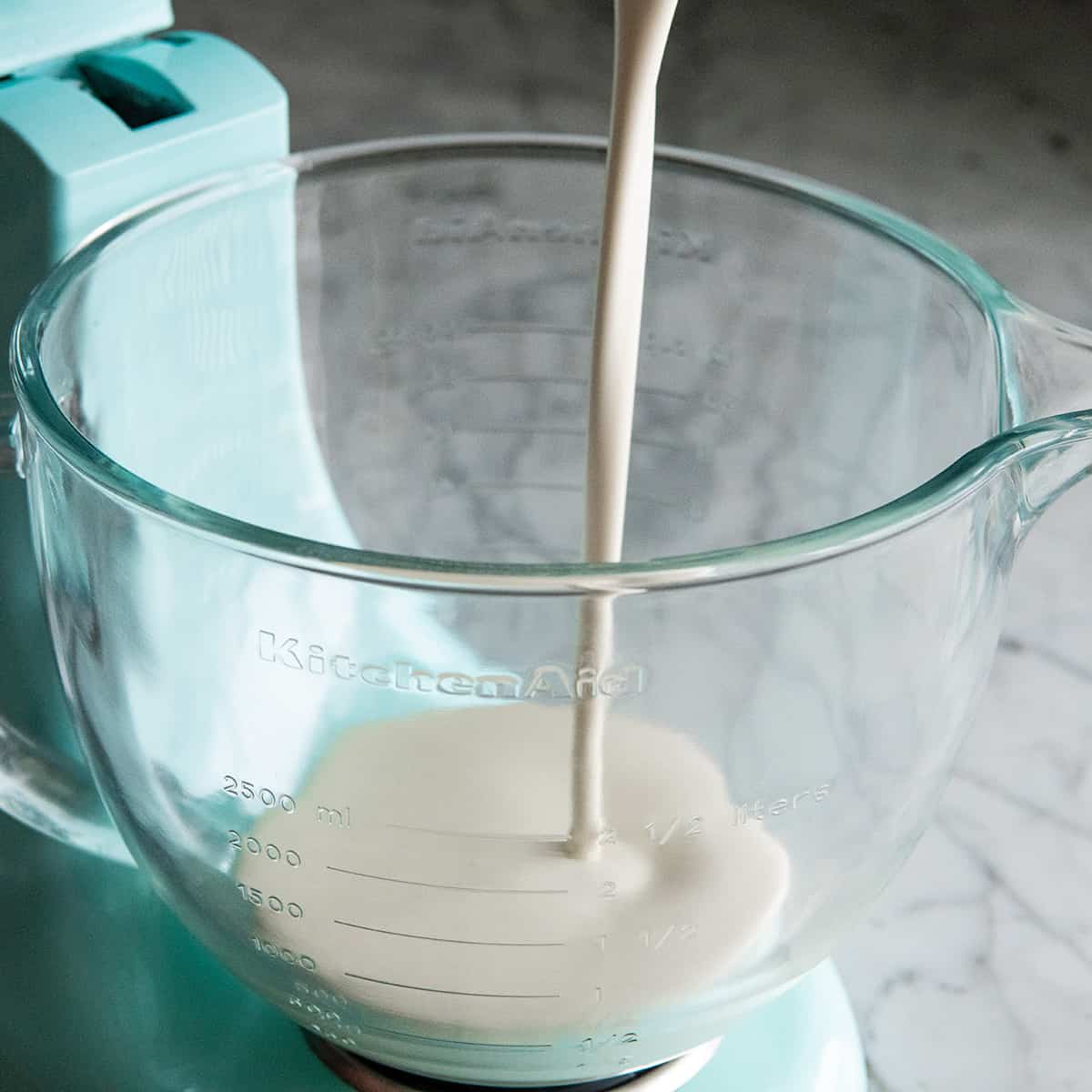 How to Make Whipped Cream - pouring heaving cream into a mixing bowl