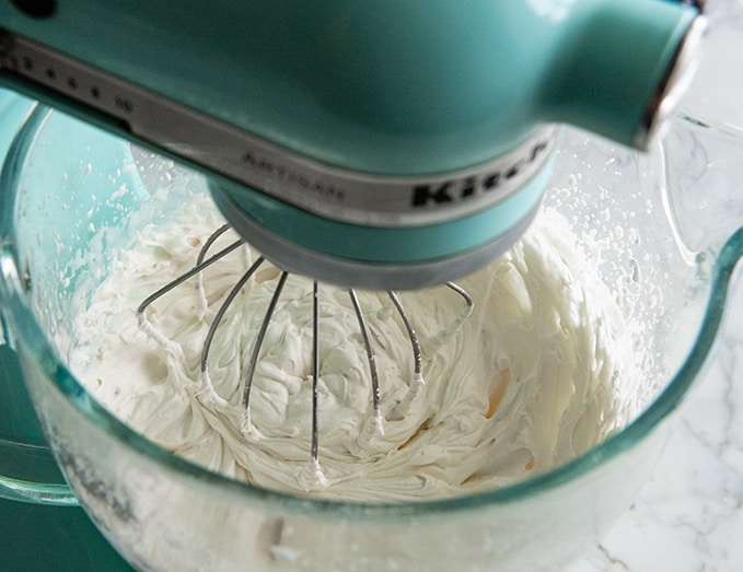 whipped cream being made in a standing mixer