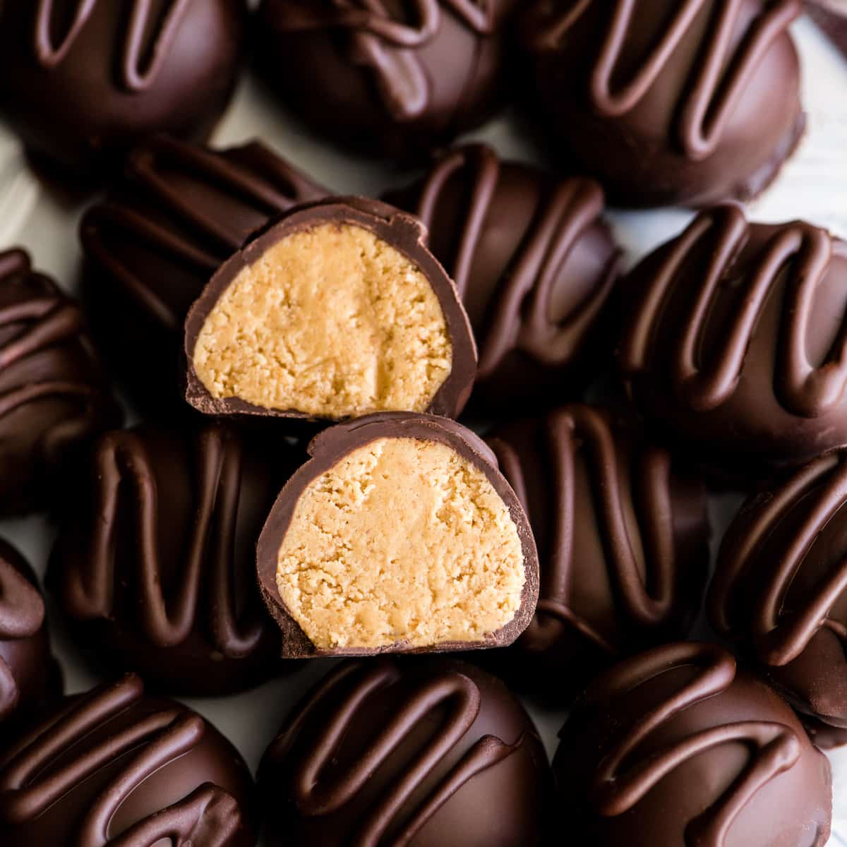 overhead view of a No-Bake Chocolate Peanut Butter Ball cut in half so the center is showing sitting on top of 15 other balls.