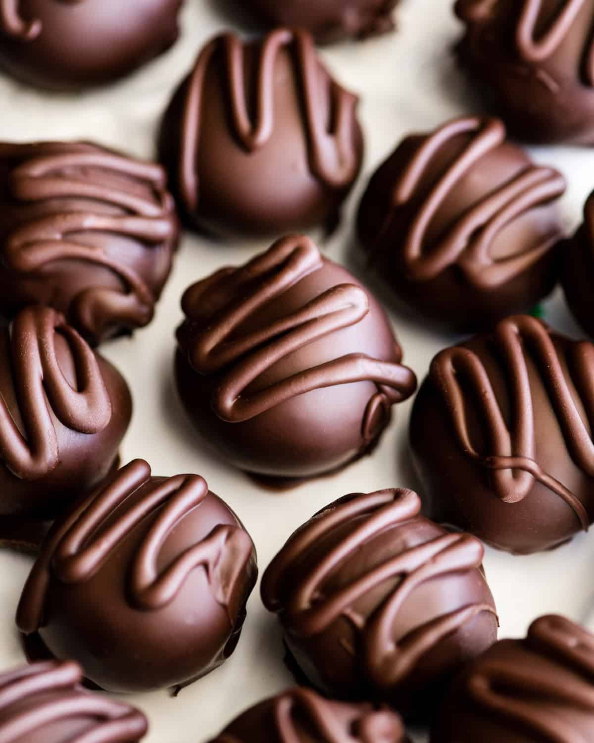 10 No-Bake Chocolate Peanut Butter Balls with a chocolate drizzle