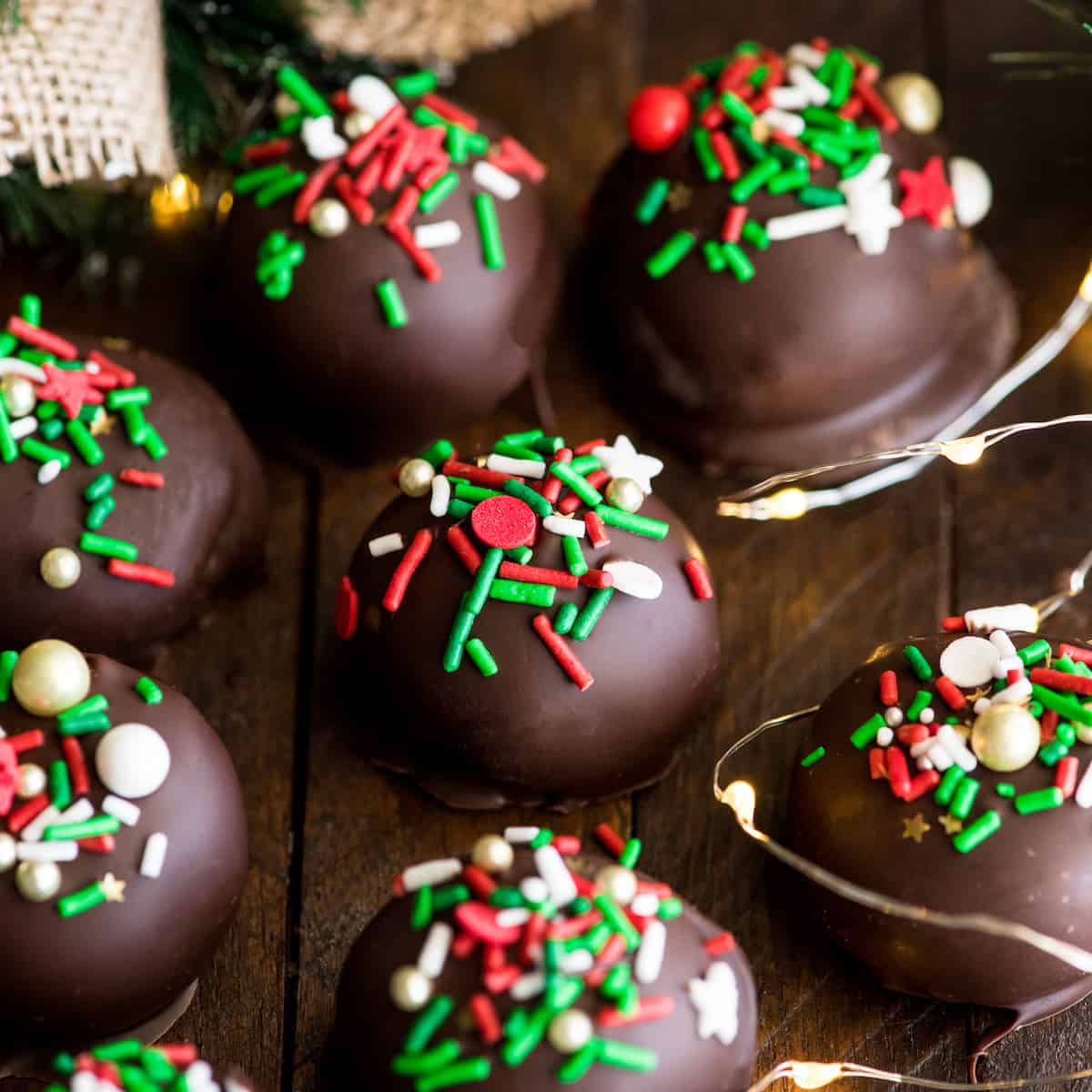 front view of 7 chocolate peanut butter balls with Christmas sprinkles