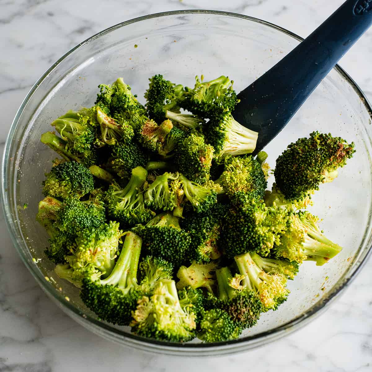 photo showing how to roast broccoli - stirring broccoli in a bowl