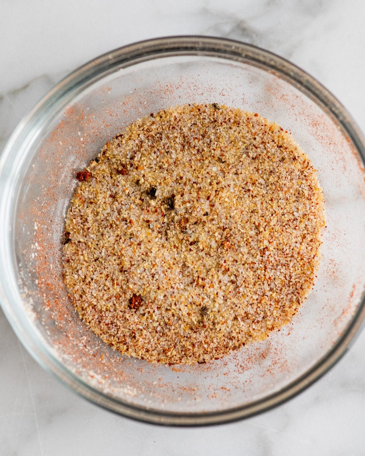 making oven roasted broccoli - paprika, garlic powder, sea salt and pepper in a small glass bowl after mixing