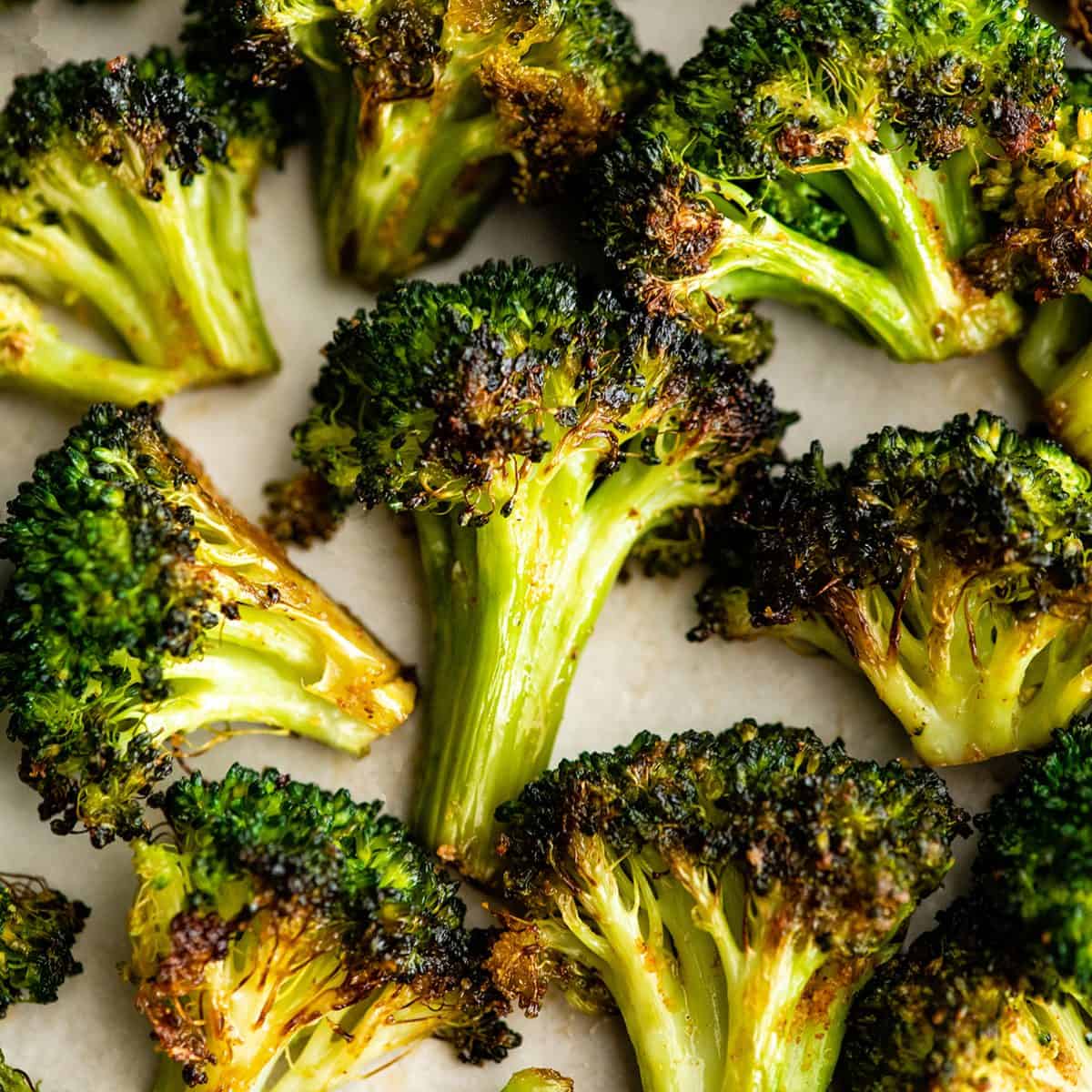 up close photo of 9 pieces of oven roasted broccoli on a plate