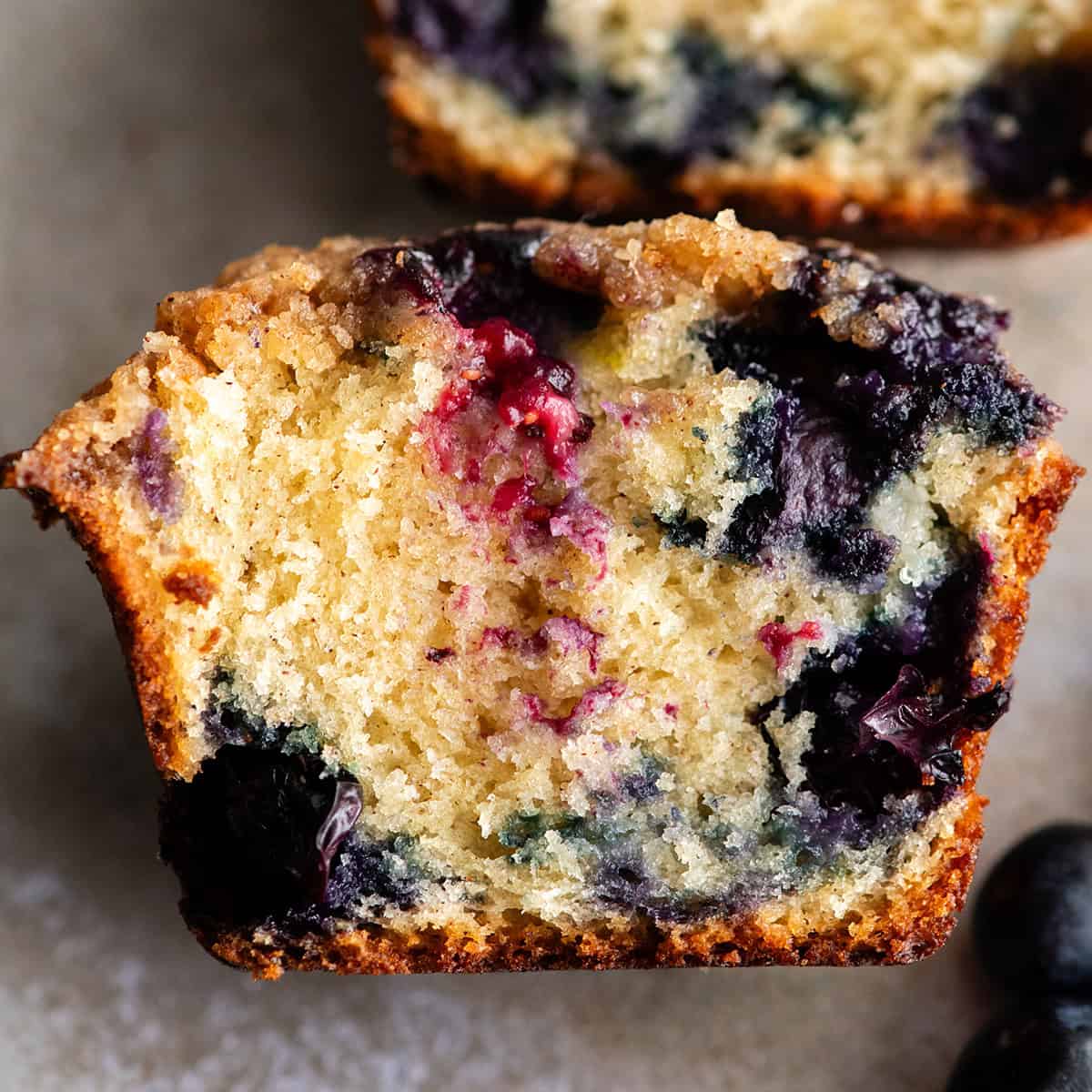up close photo of a blueberry muffin cut in half so the inside is showing