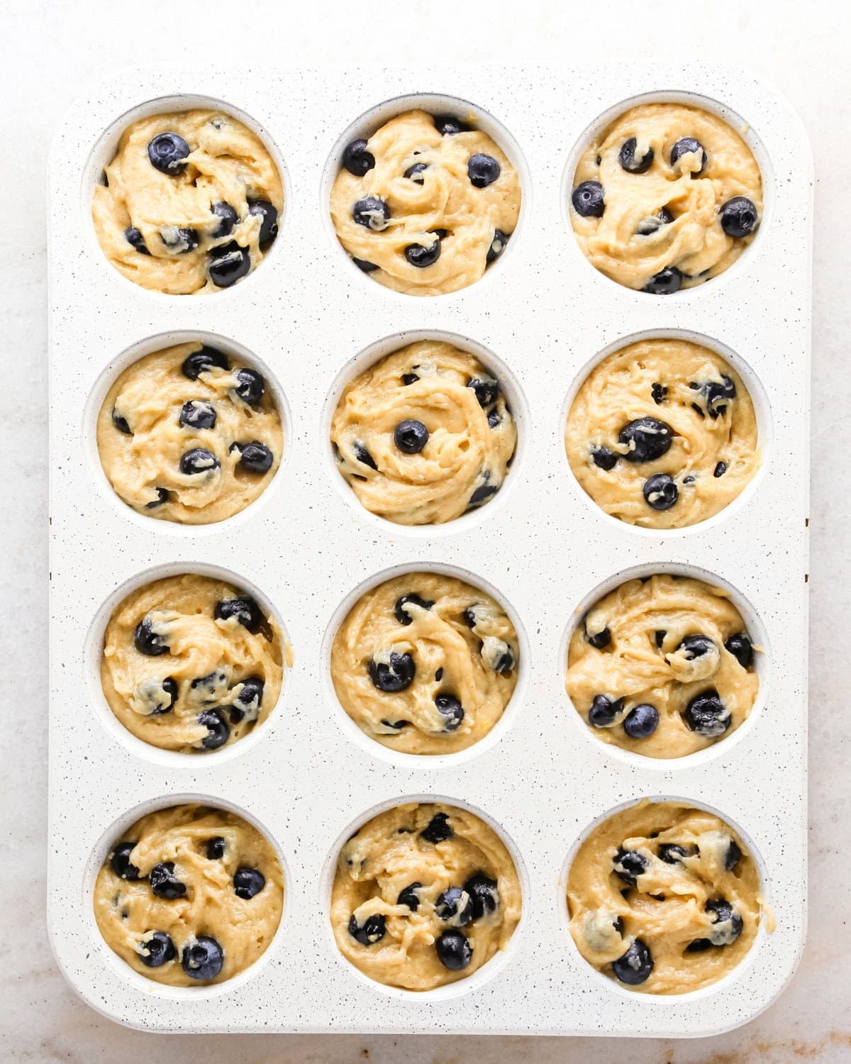 blueberry  muffins batter in a muffin pan before baking