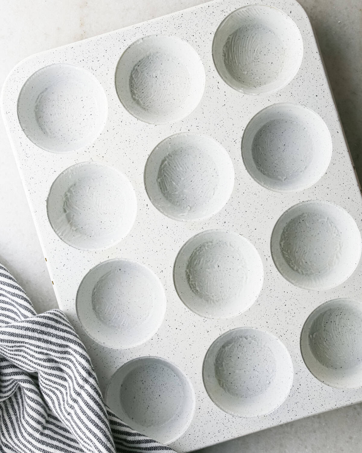 a buttered 12-cup muffin pan to be used to make blueberry muffins