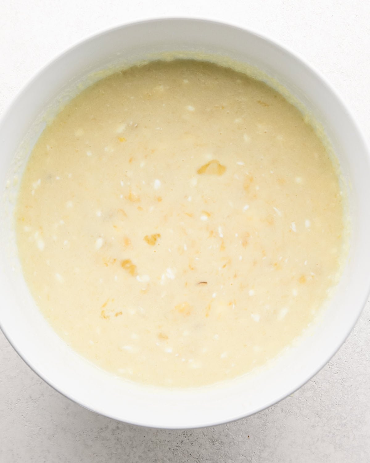 the wet ingredients combined in a white bowl to make this banana cake recipe