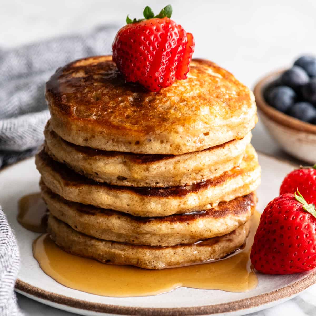 a stack of 5 Whole Wheat Pancakes with syrup and strawberries