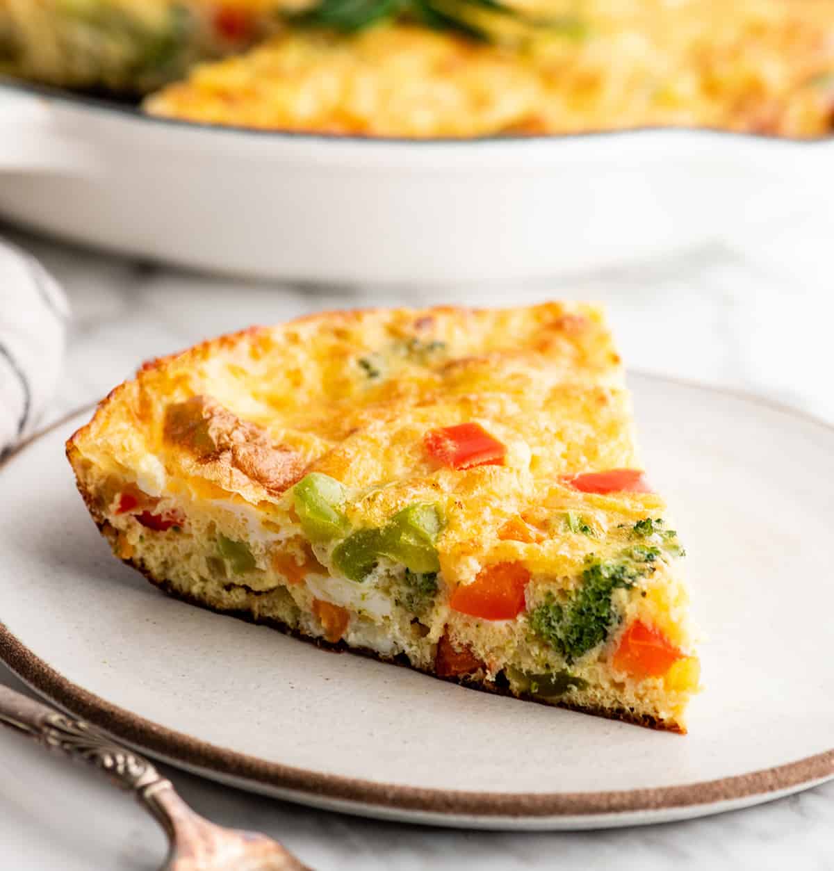 front view of a slice of vegetable frittata on a plate