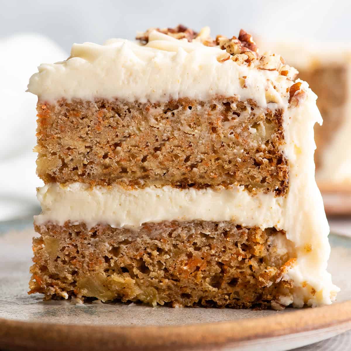 a slice of healthy carrot cake with cream cheese frosting and pecans 