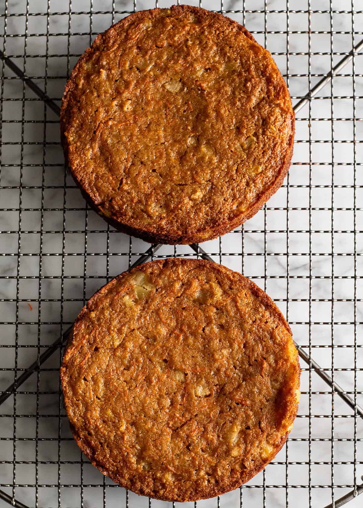 two Healthy Carrot Cake rounds on a wire cooling rack