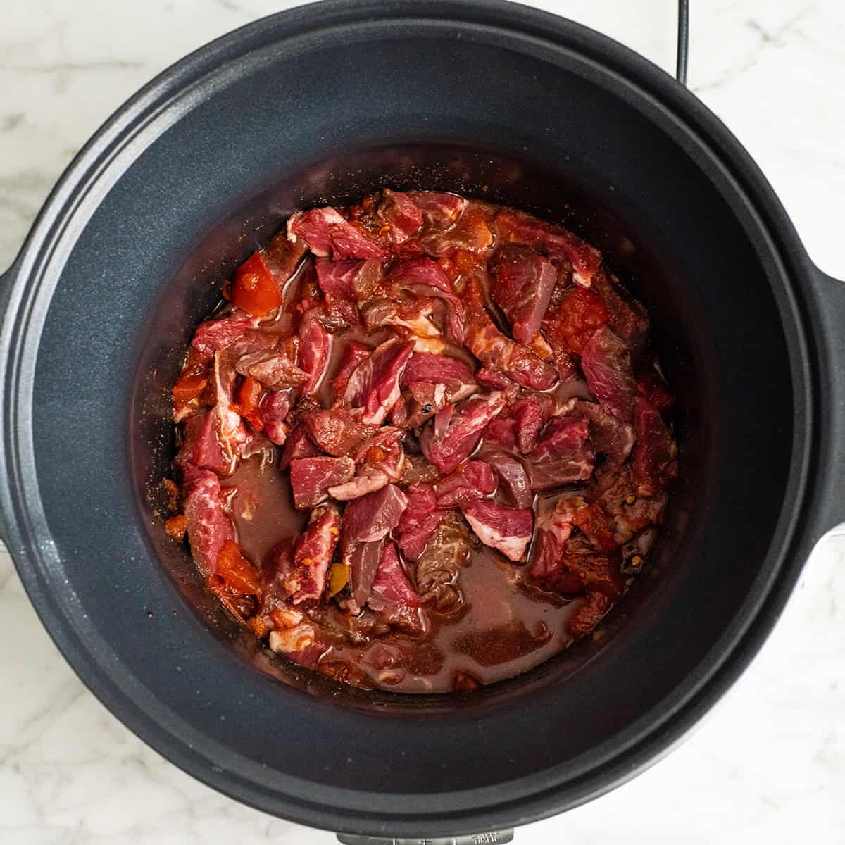 slow cooker pepper steak in a crock pot before cooking