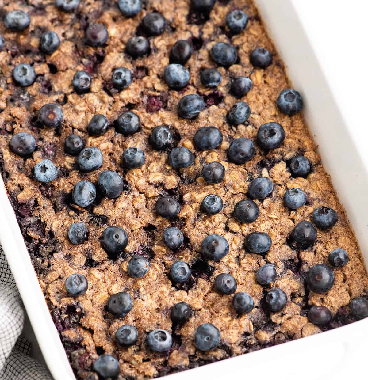 blueberry baked oatmeal in a baking dish topped with blueberries after baking