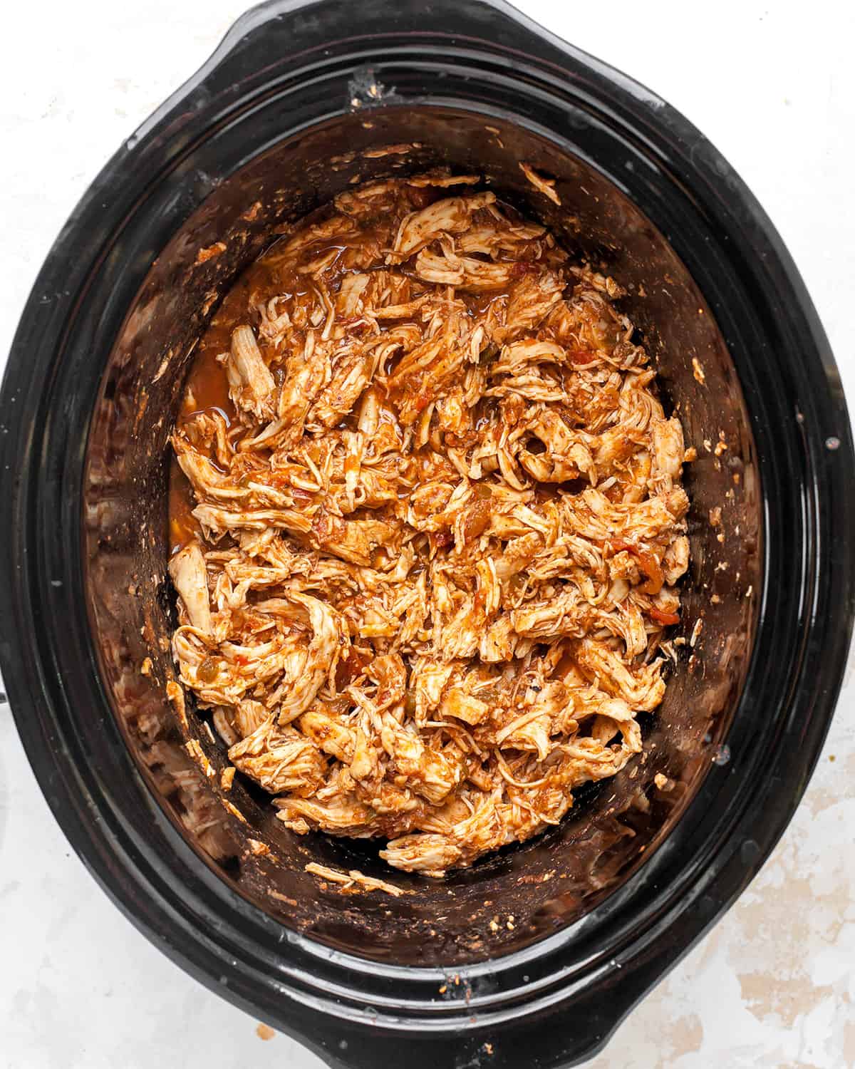 shredded mexican chicken in the container of a slow cooker