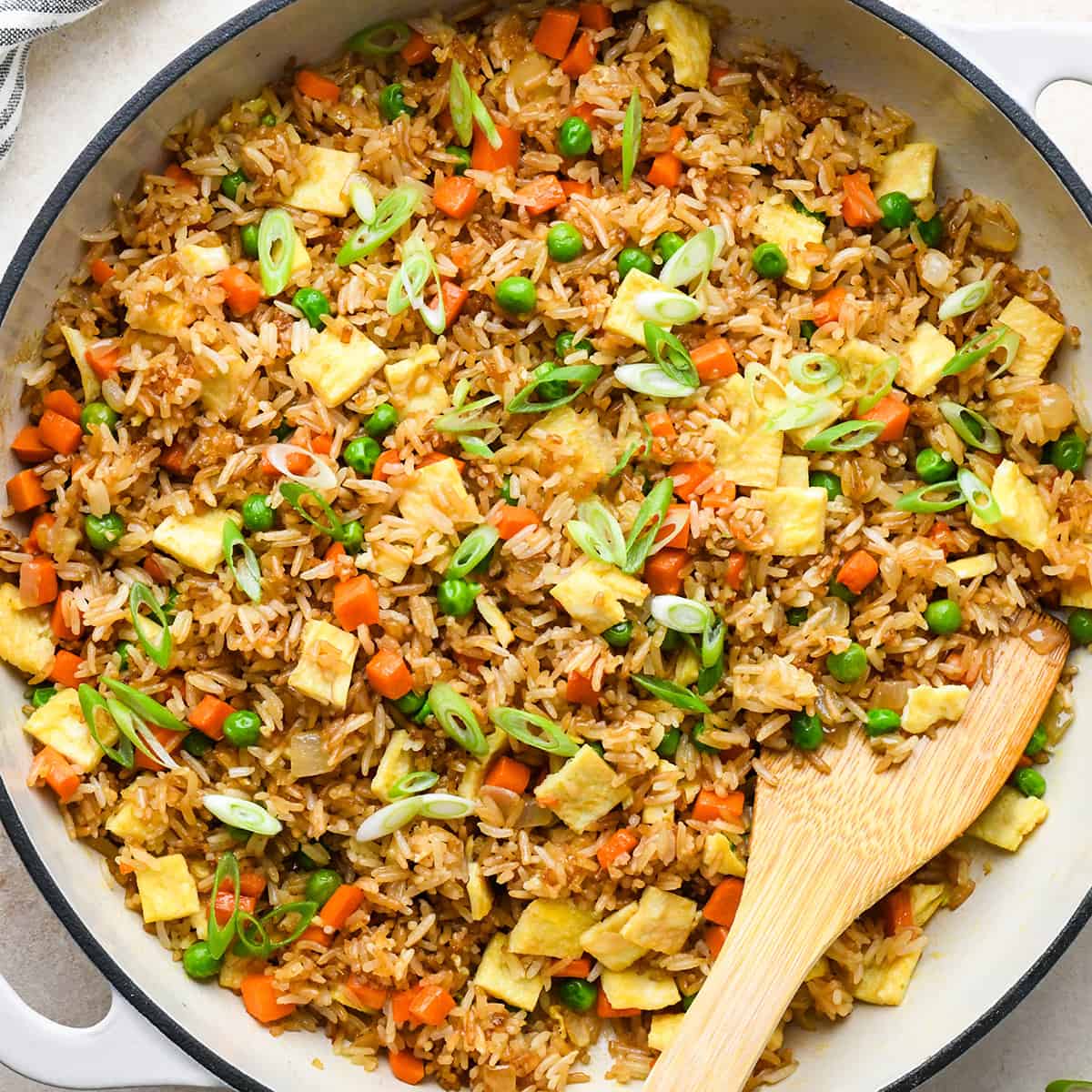 Fried Rice Recipe in a pan with a wooden serving spoon