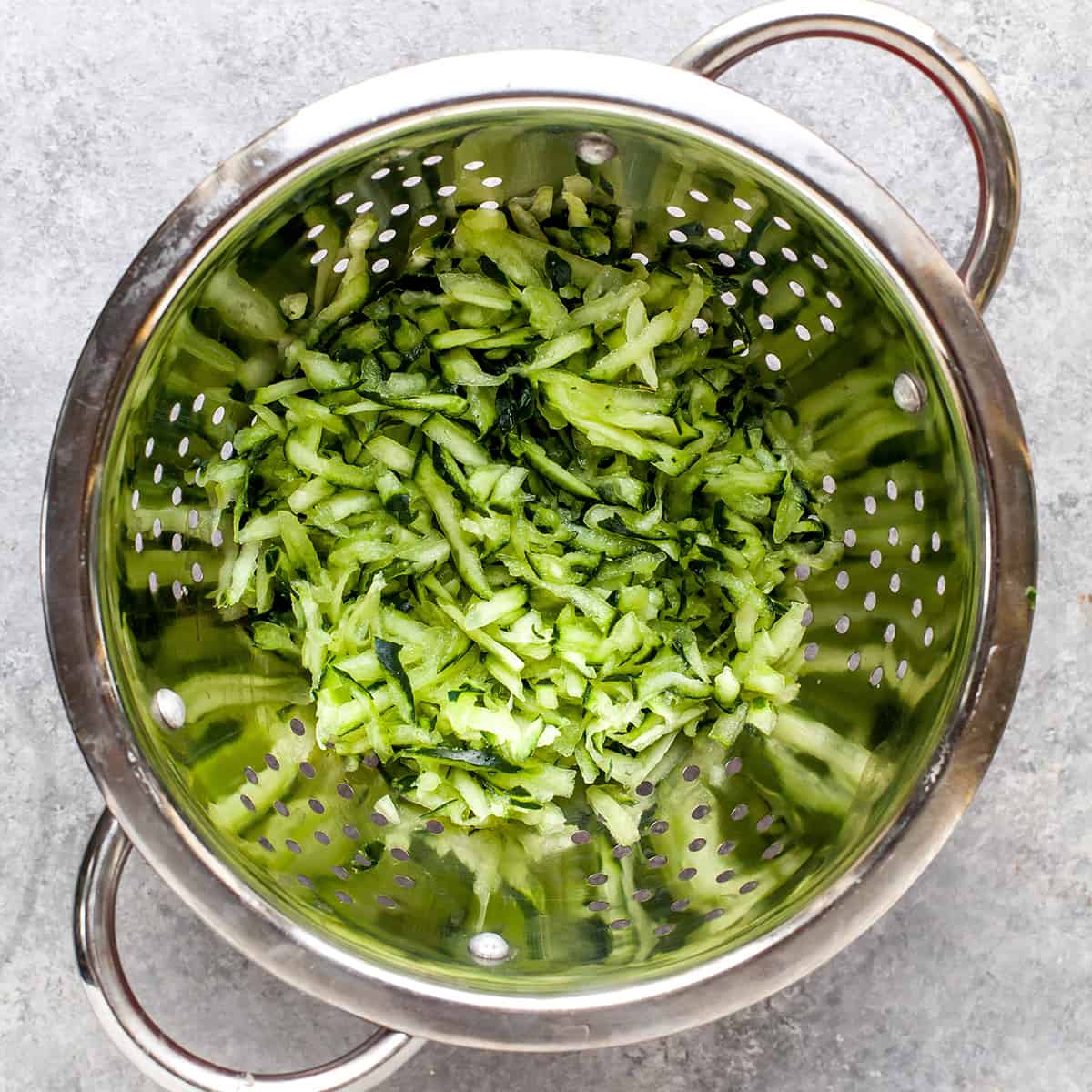 How to Make Tzatziki Sauce - shredded cucumber in a colander to remove water